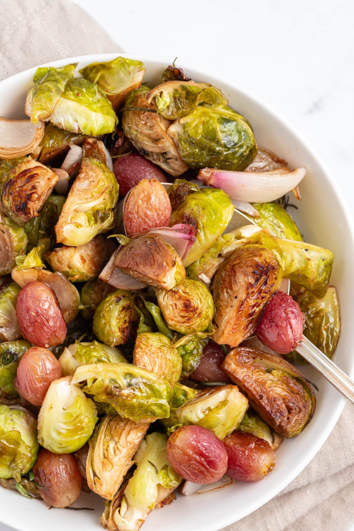 close up balsamic brussels sprouts with grapes and shallots
