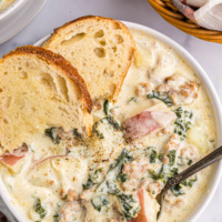 bowl of potato sausage and kale soup with slices of bread