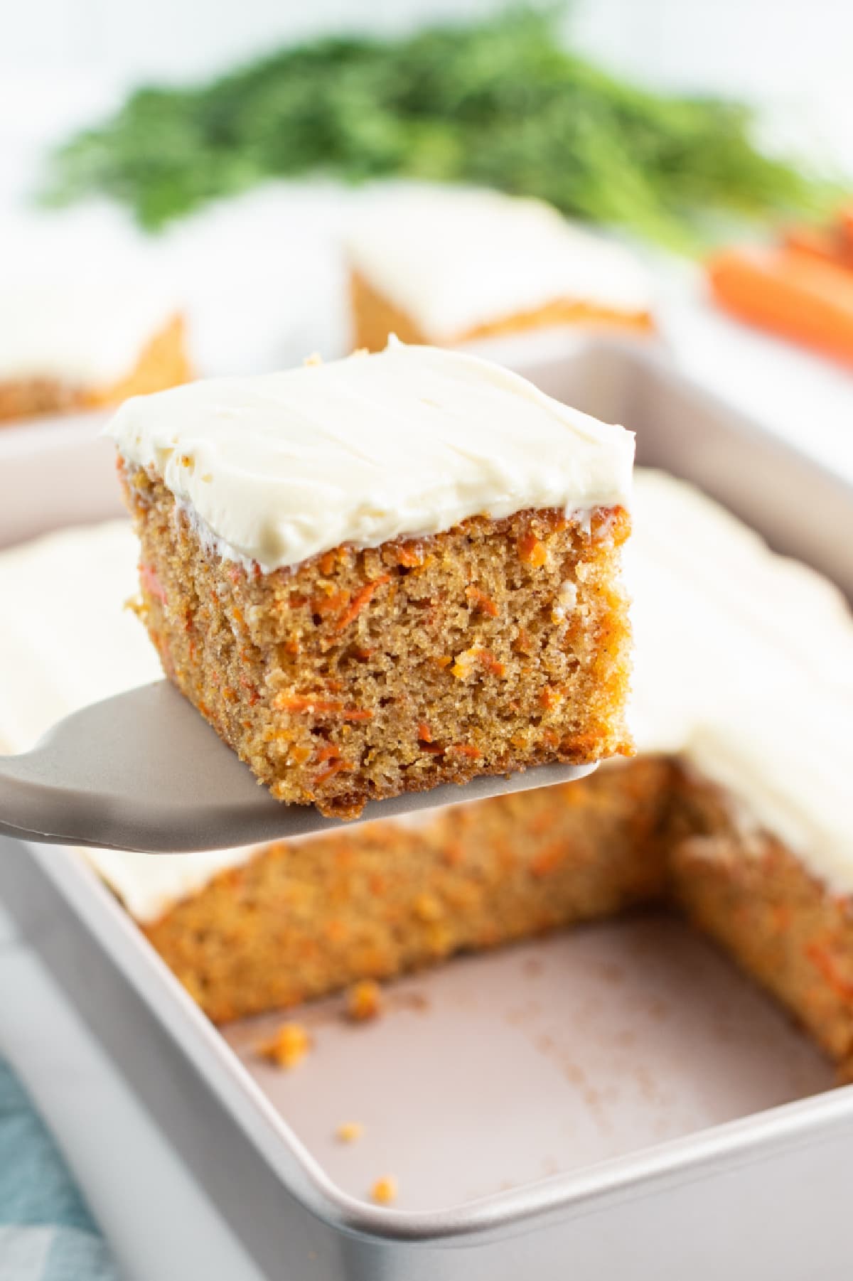 spatula taking out slice of carrot sheet cake