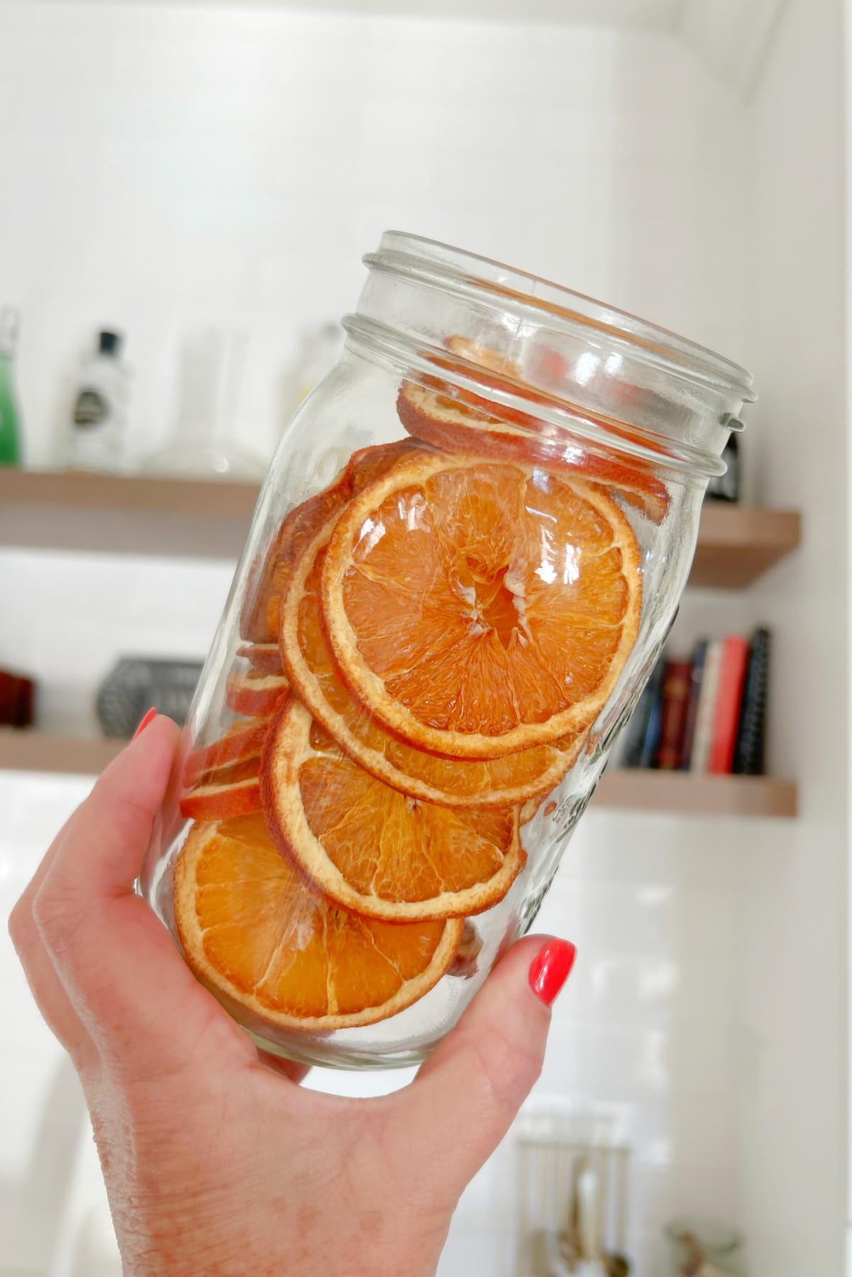 hand holding jar of dehydrated oranges