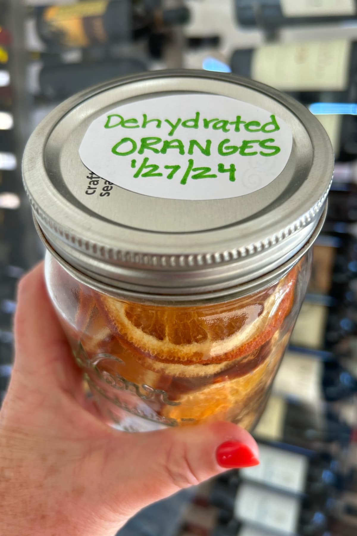 hand holding jar of dehydrated orange slices
