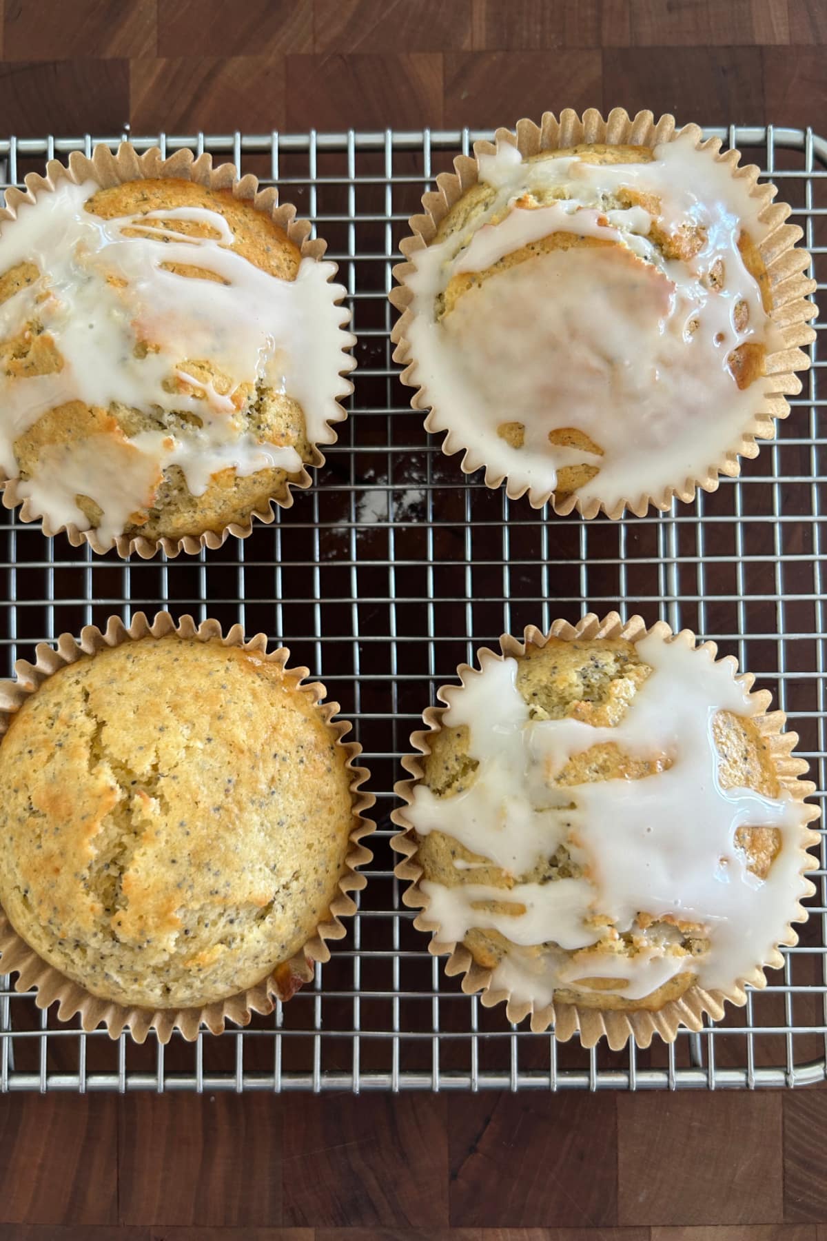 lemon poppy seed muffins on baking rack with some of them topped with glaze