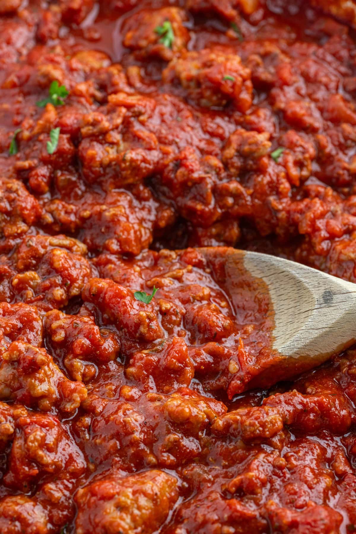 close up meat sauce with wooden spoon