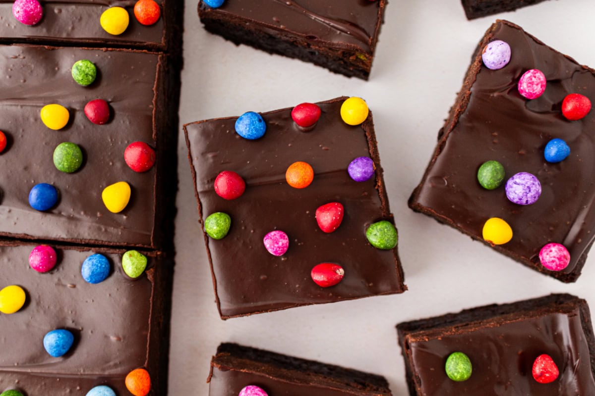 Cosmic Brownies are a fudgy, chocolatey copycat of the classic treat with ganache and colorful candy-coated chips. Easy and nostalgic! several cosmic brownies