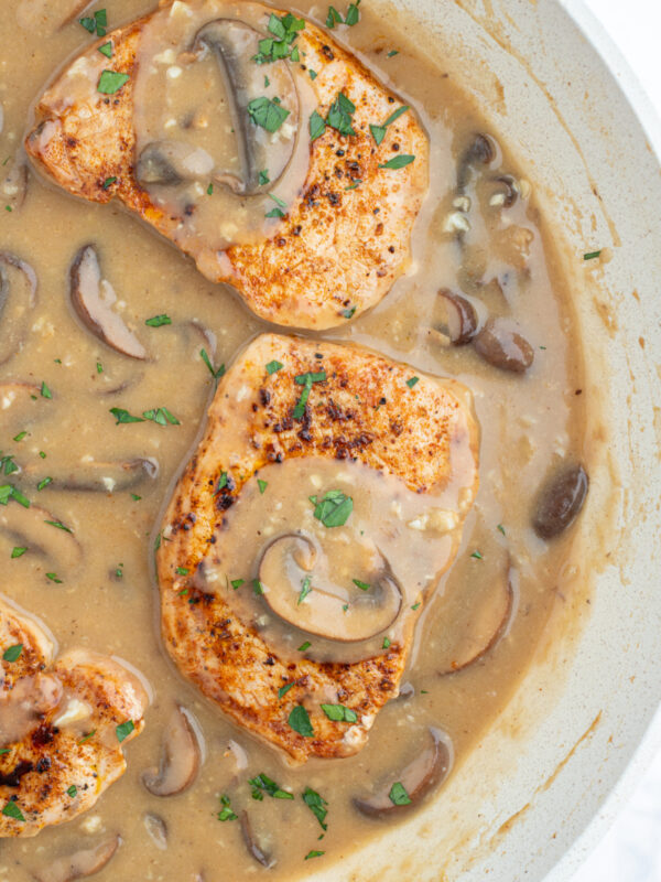 skillet showing pork chops with mushroom gravy
