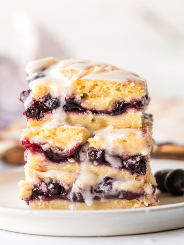 three blueberry pie bars stacked on plate