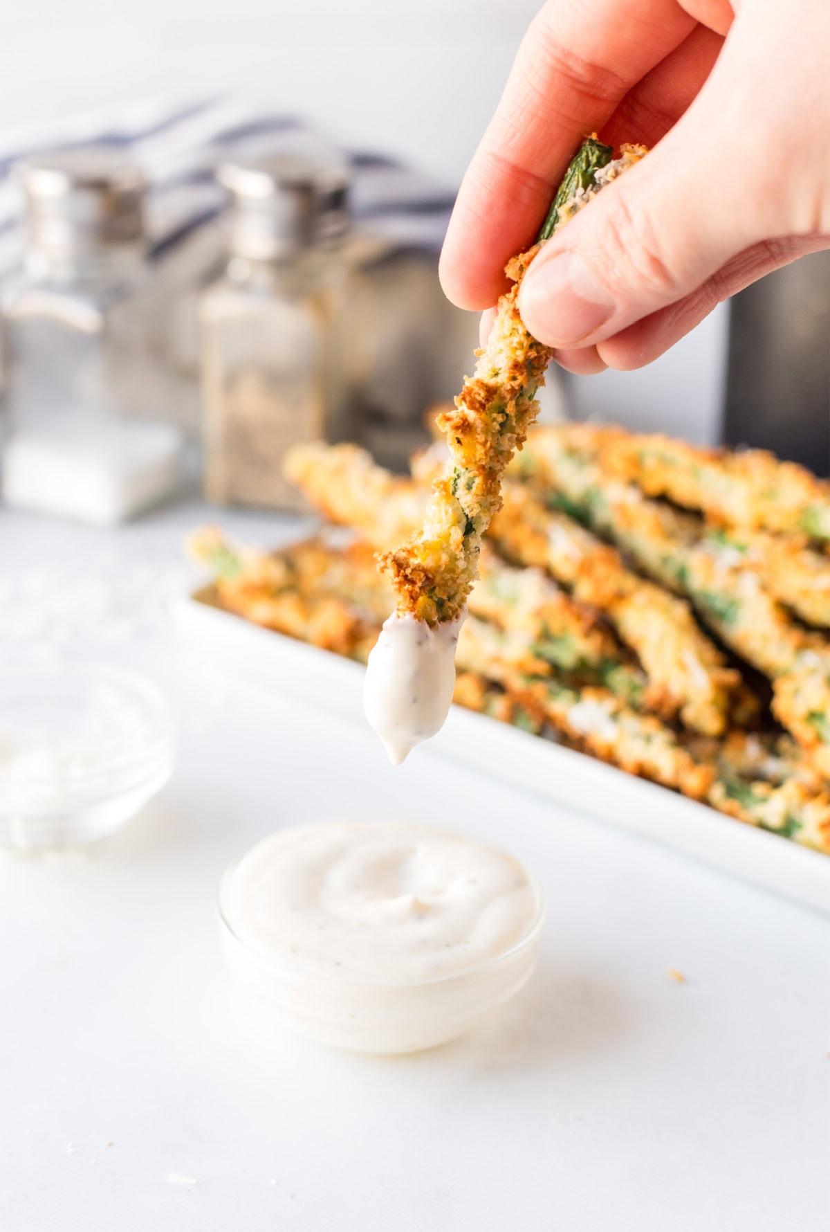 dipping air fryer green bean into ranch dressing