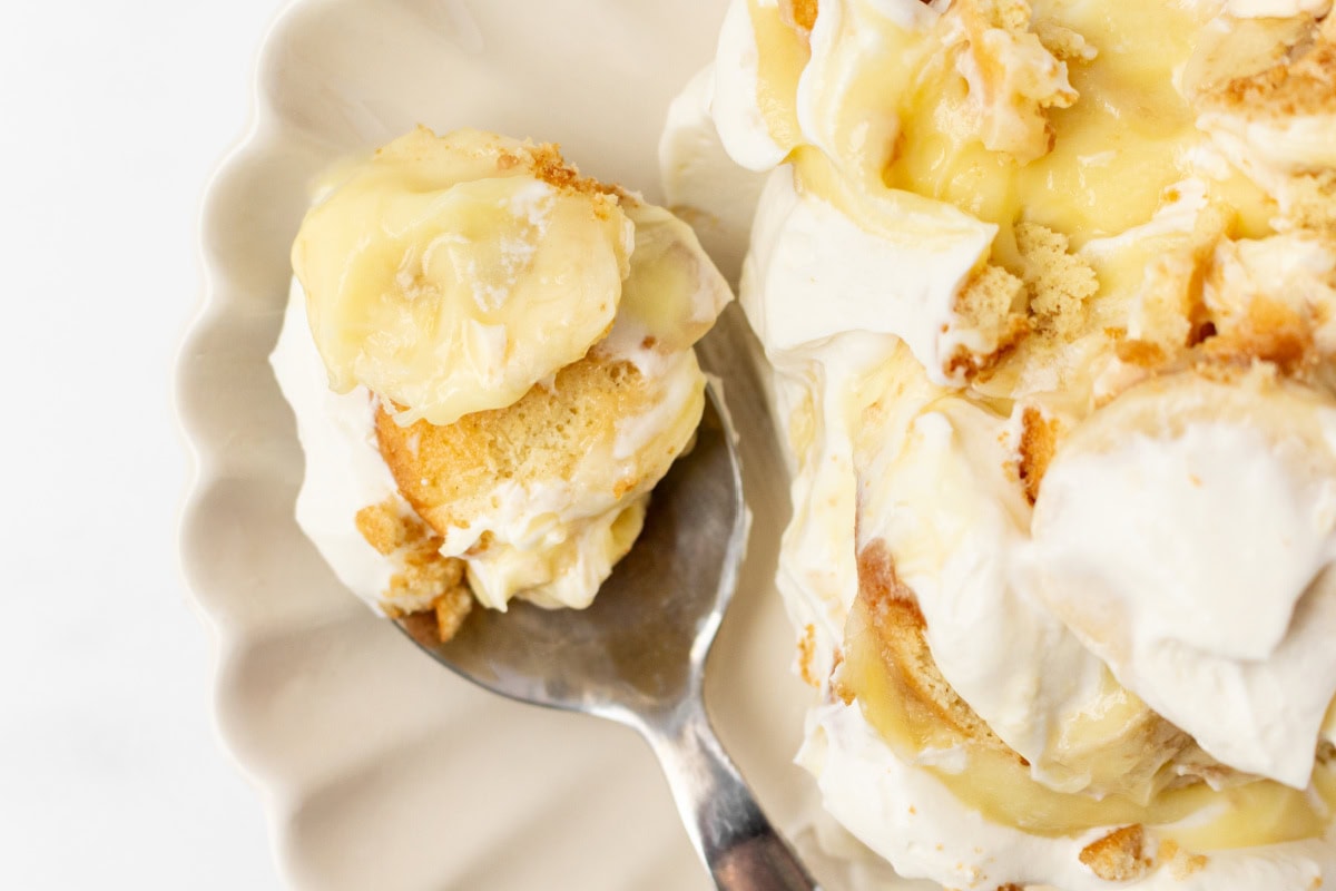This Banana Pudding Trifle is the ultimate crowd-pleasing dessert! Layers of banana pudding, cheesecake whipped cream, fresh bananas, and Nilla wafers—easy and no bake! serving of banana pudding trifle on plate