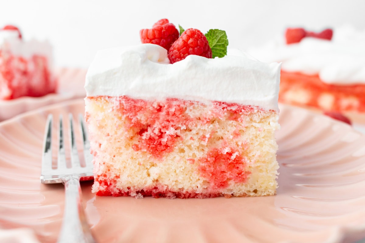 Easy Jello Poke Cake recipe from RecipeGirl.com : raspberry poke cake, strawberry poke cake slice of jello poke cake looking from side