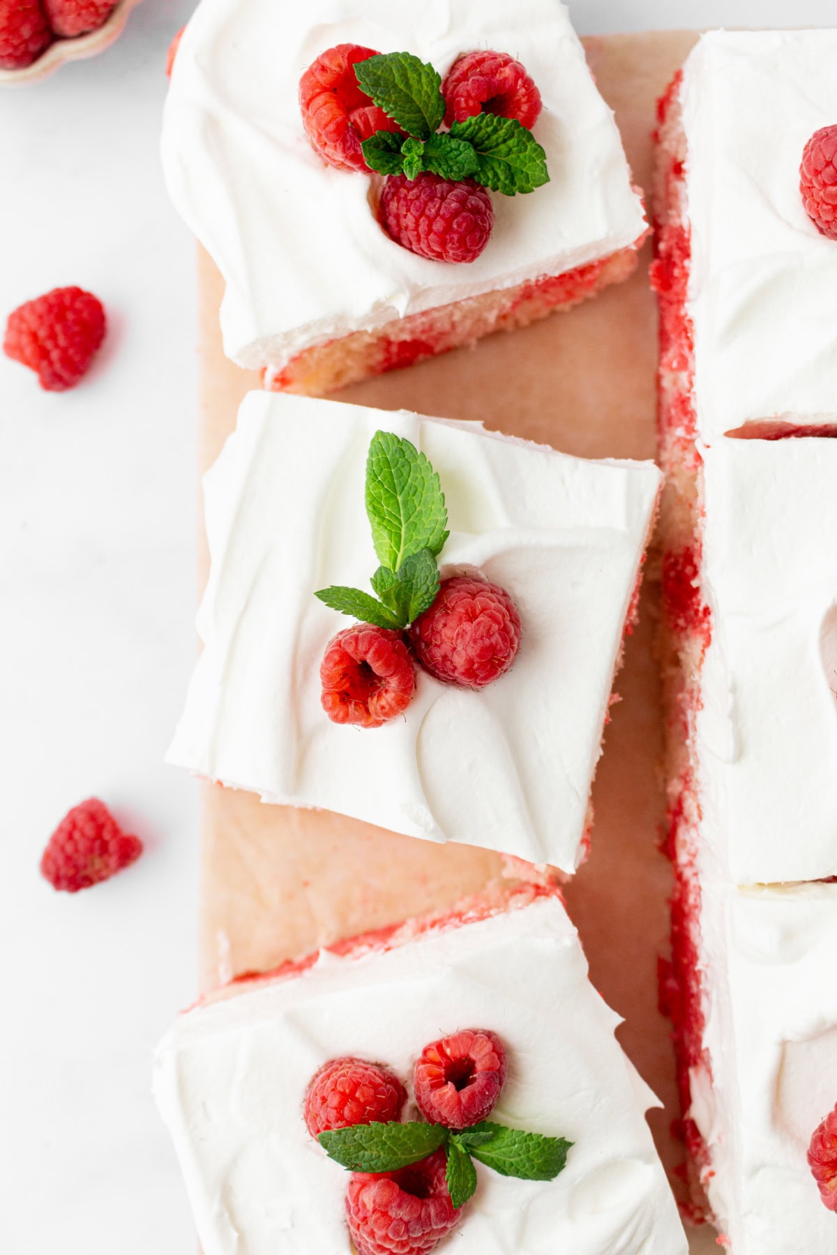 Easy Jello Poke Cake recipe from RecipeGirl.com : raspberry poke cake, strawberry poke cake overhead look at slices of jello poke cake