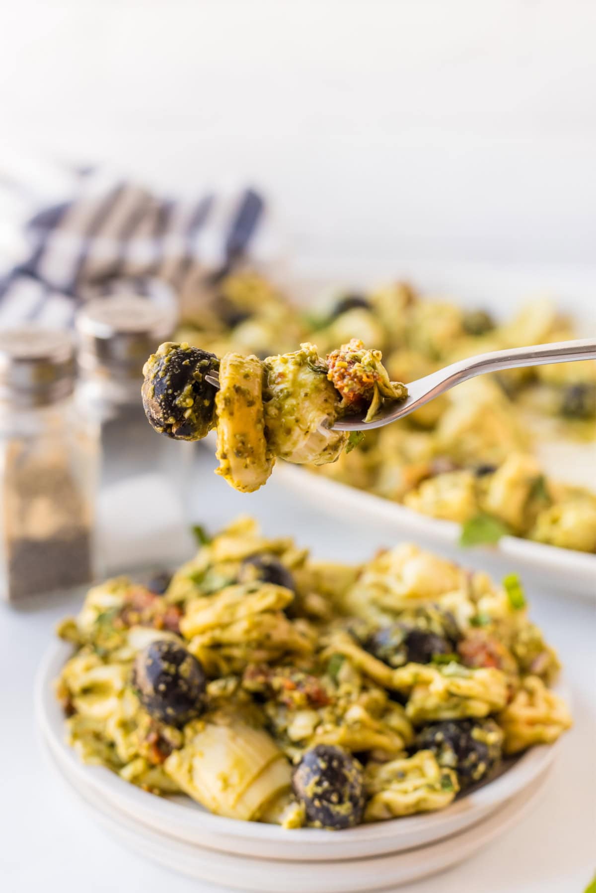 Pesto Tortellini Pasta Salad recipe from RecipeGirl.com fork full of pesto tortellini pasta salad