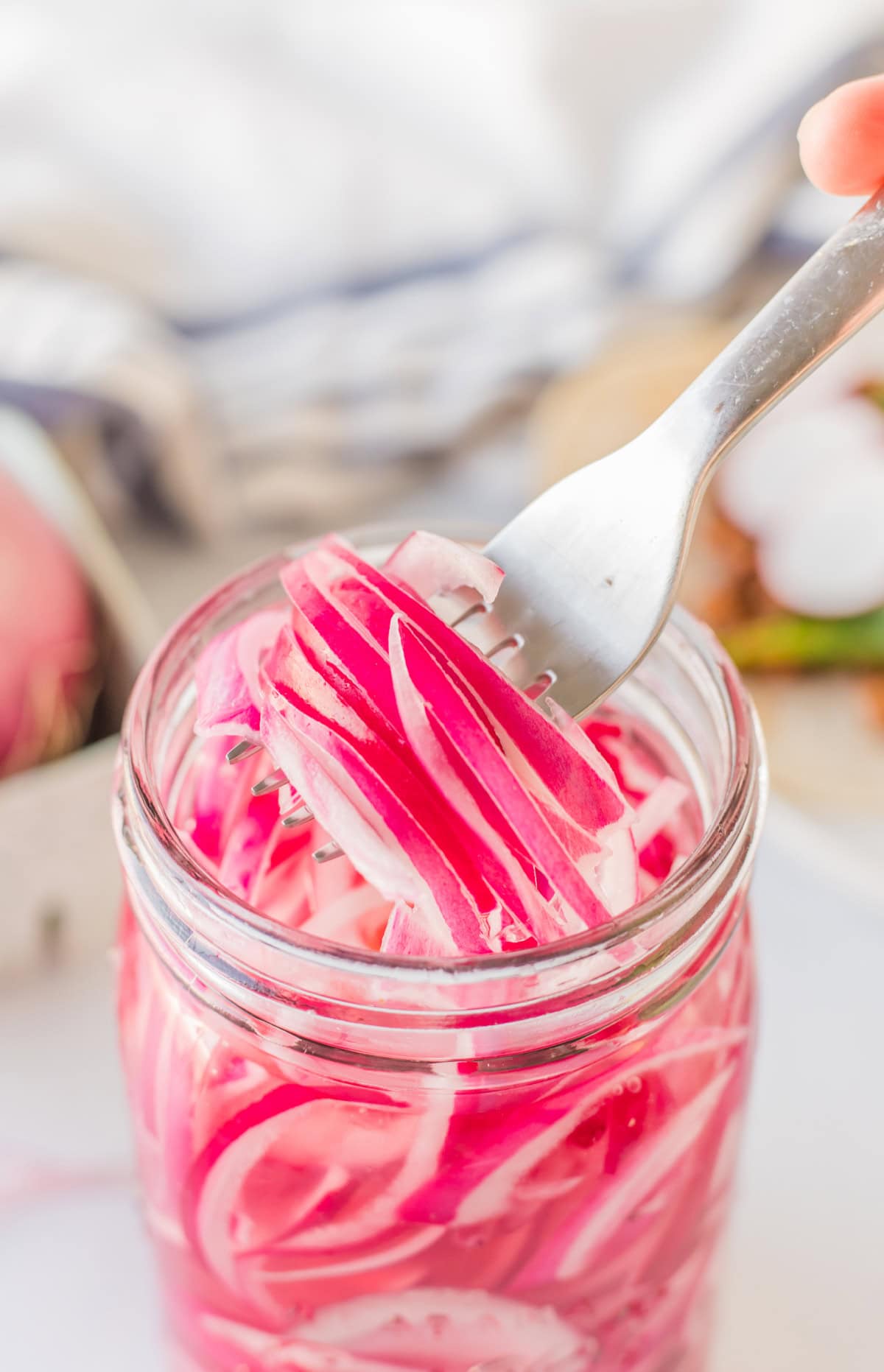 Quick Pickled Red Onions recipe from RecipeGirl.com : easy pickled onions fork pulling pickled red onions out of jar