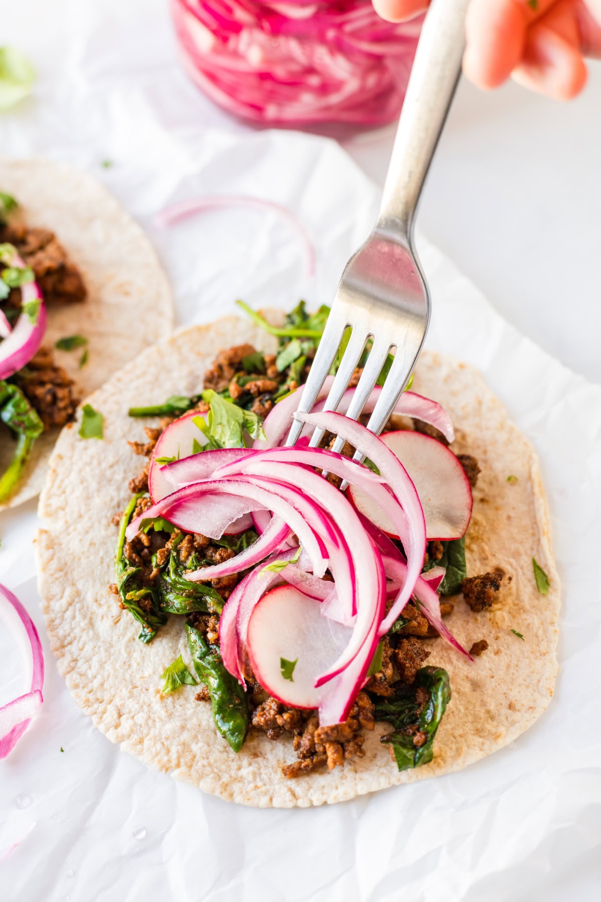 Quick Pickled Red Onions recipe from RecipeGirl.com : easy pickled onions fork putting pickled red onions on tacos