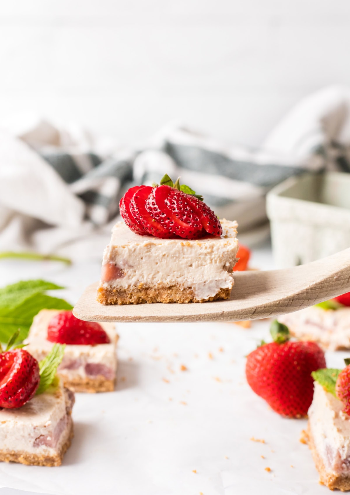 Strawberry Cheesecake Bars recipe from RecipeGirl.com spatula holding a strawberry cheesecake bar