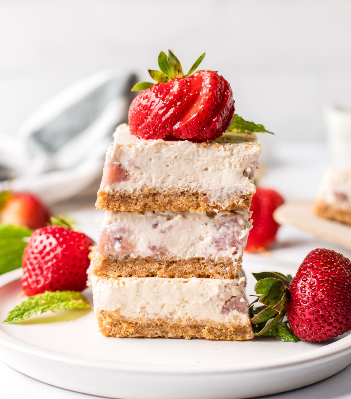 Strawberry Cheesecake Bars recipe from RecipeGirl.com three strawberry cheesecake bars stacked on plate