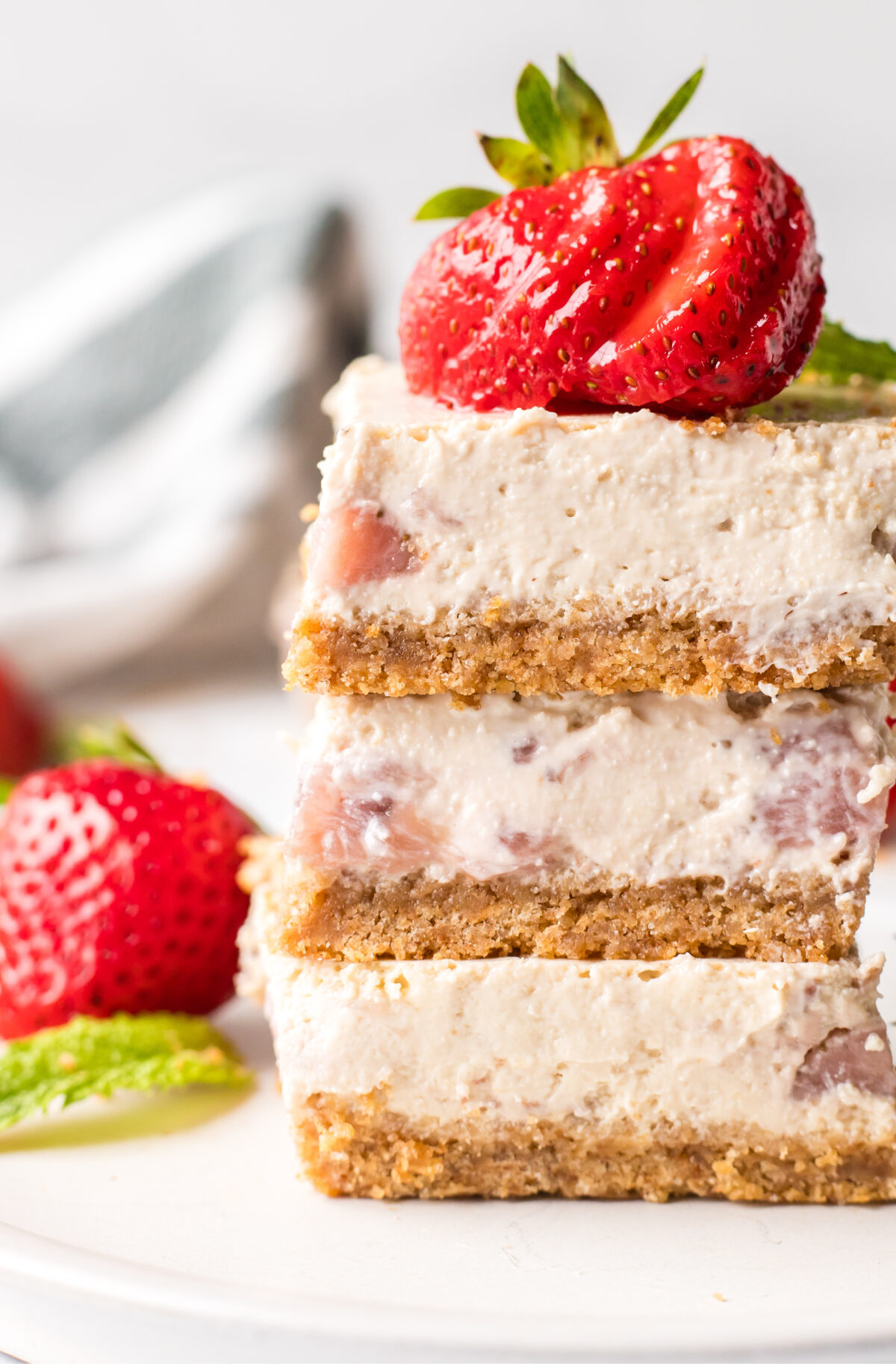 Strawberry Cheesecake Bars recipe from RecipeGirl.com stack of three strawberry cheesecake bars