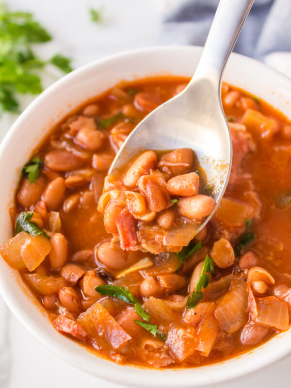 A bowl of ranch style beans with a spoon