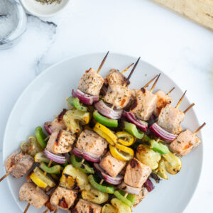 overhead shot of grilled salmon and veggie kabobs on plate
