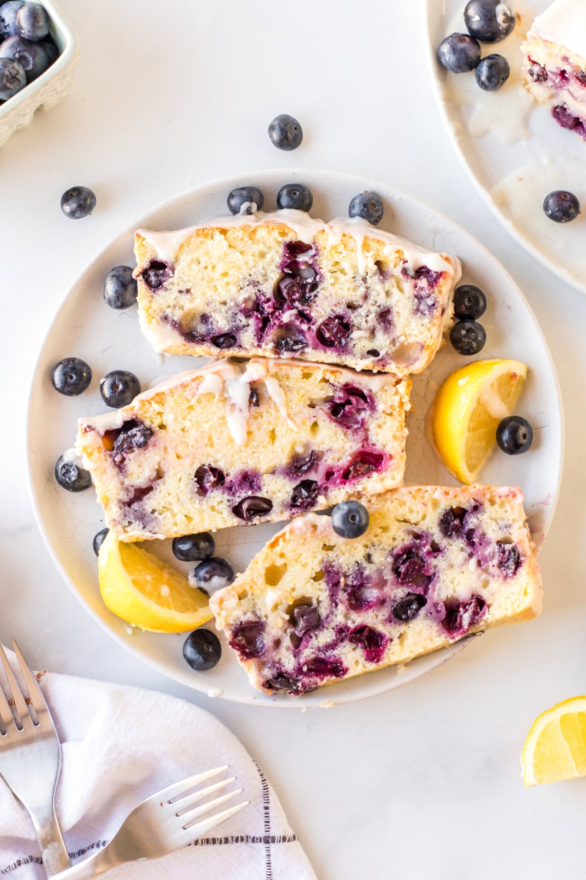 Glazed Lemon Blueberry Bread recipe from RecipeGirl.com : blueberry lemon loaf cake three slices of lemon blueberry bread on plate