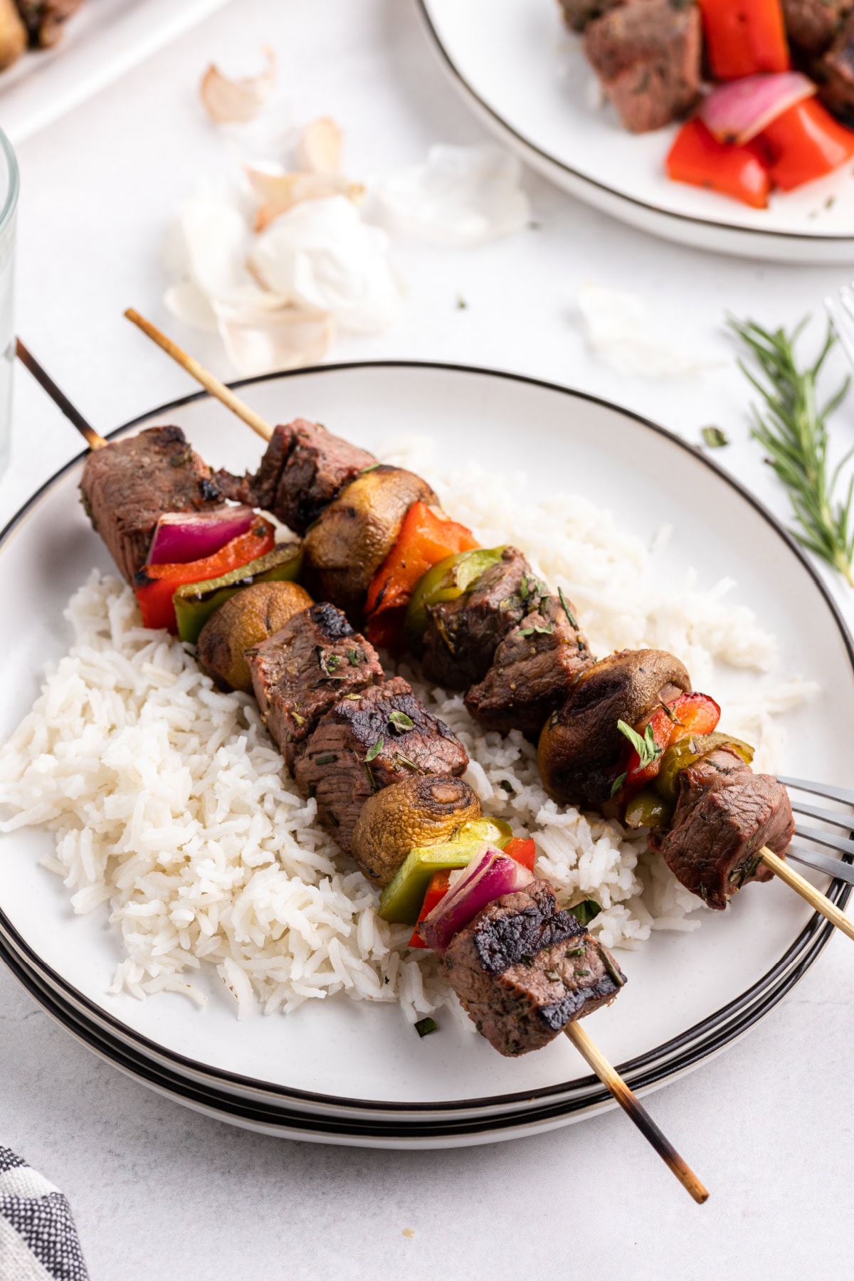 serving of steak kabobs on plate with rice