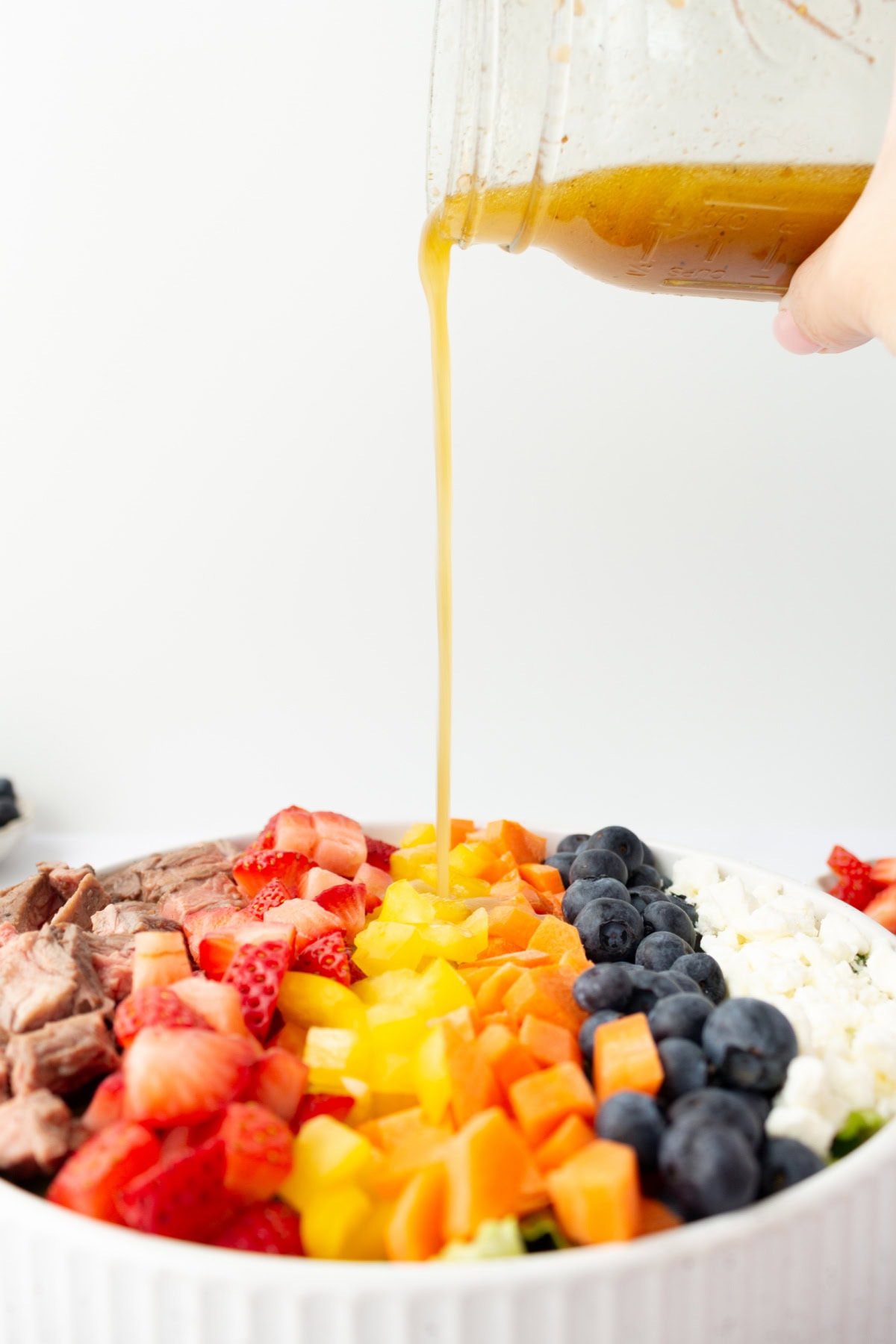 pouring dressing onto steak salad
