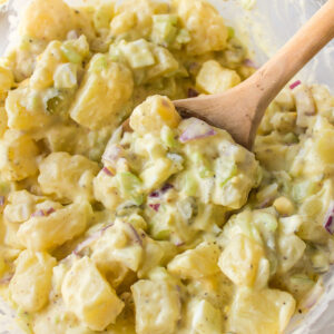 spoon in bowl of sweet pickle potato salad
