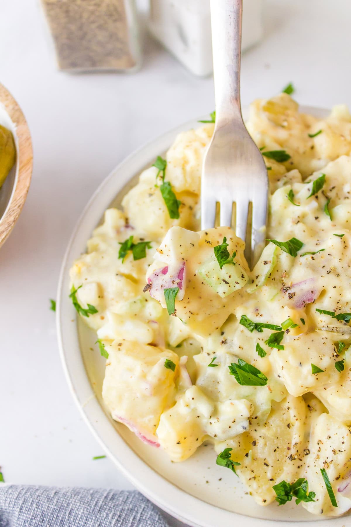 Sweet Pickle Potato Salad : a creamy potato salad recipe from RecipeGirl.com fork in sweet pickle potato salad