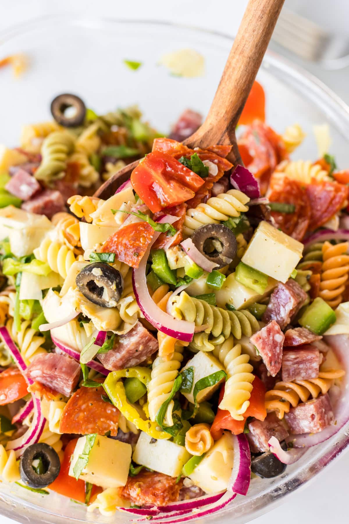 Antipasto Pasta Salad Recipe from RecipeGirl.com antipasto pasta salad in bowl with spoon