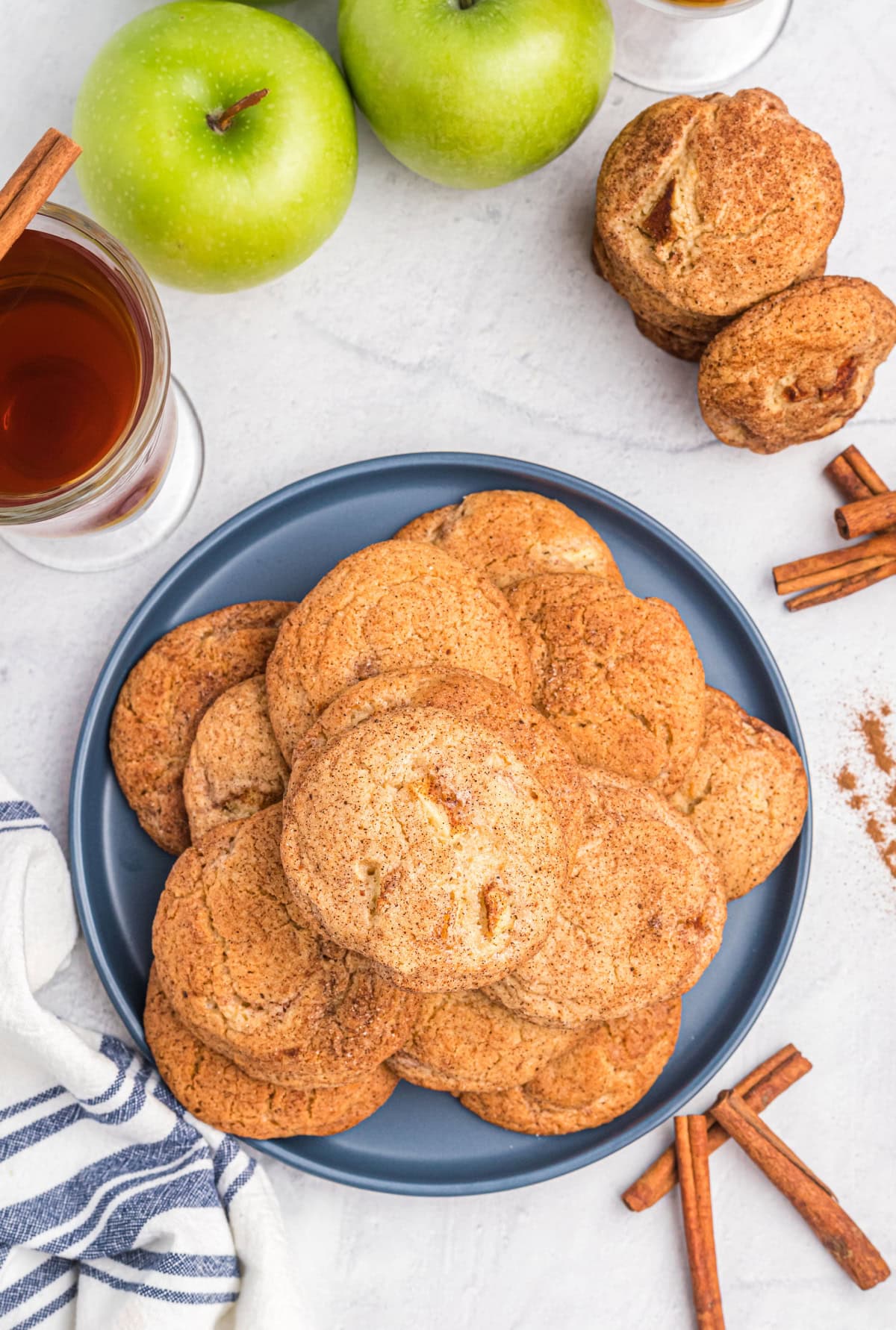 Apple Snickerdoodles are traditional snickerdoodles filled with apple cider syrup and fresh apples to create the perfect fall cookie recipe. Recipe from RecipeGirl.com overhead shot of platter of apple snickerdoodles