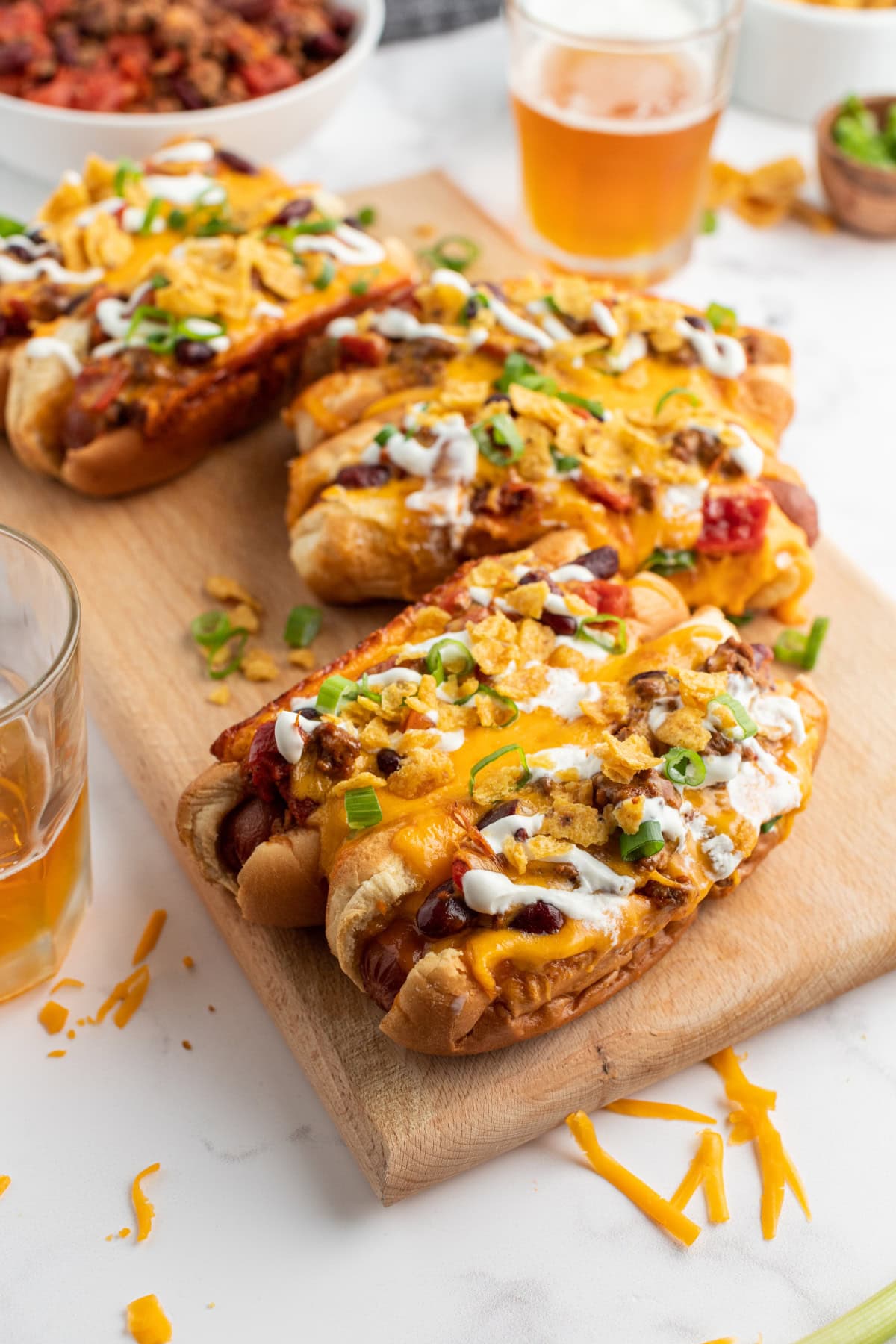 groups of two baked chili dogs on a board