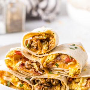 stack of breakfast burritos on a plate
