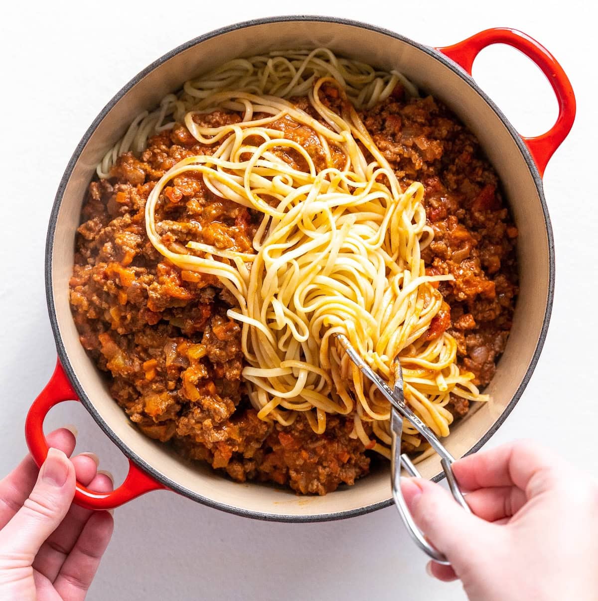 bolognese sauce in a pot with pasta on top