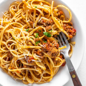 linguine with bolognese sauce in bowl with fork