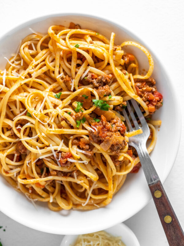 linguine with bolognese sauce in bowl with fork