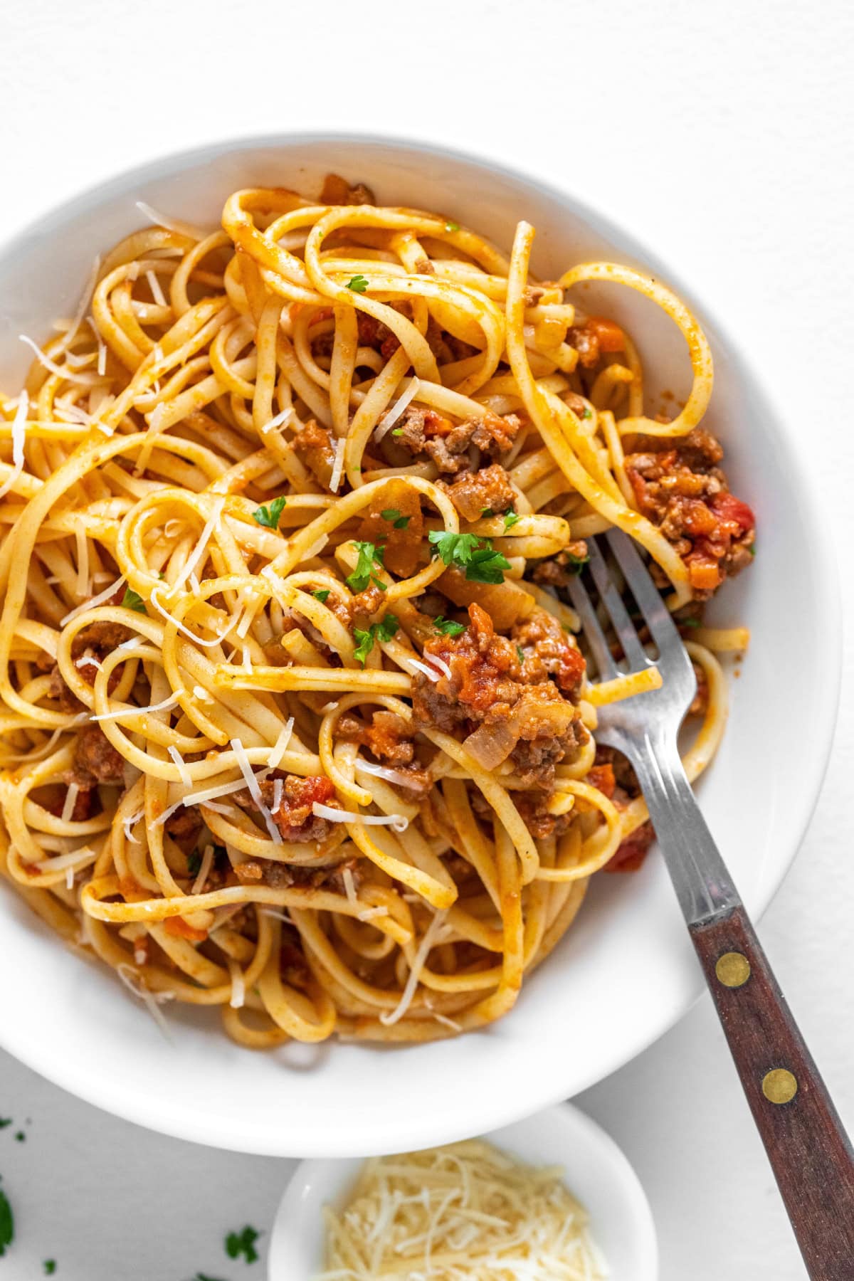 linguine with bolognese sauce in bowl with fork