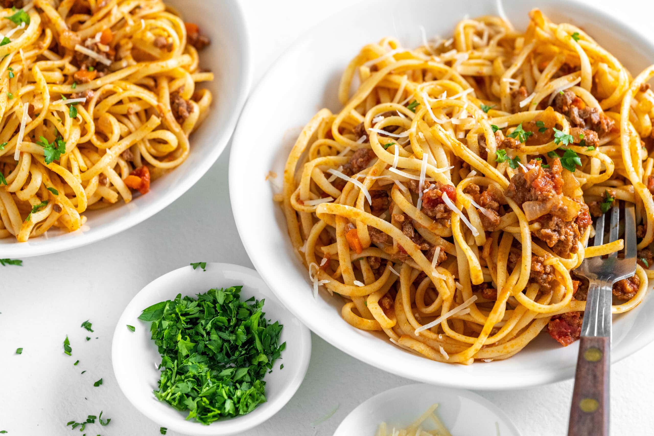 two bowls of linguine with bolognese sauce