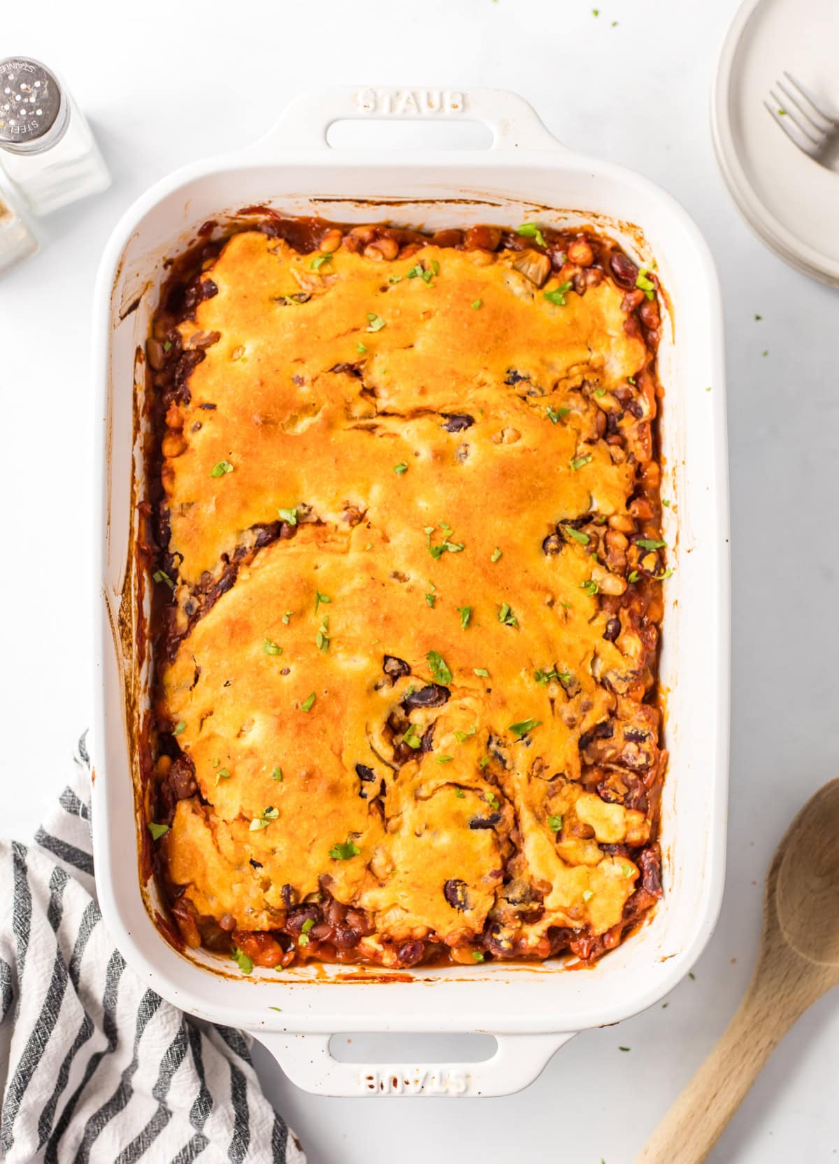 Cowboy Casserole is a hearty, baked beans and cornbread casserole full of smoky, sweet, and savory flavor — perfect for cozy family dinners or potlucks! Recipe from RecipeGirl.com. Cowboy Casserole with golden cornbread topping baked in a 9x13 dish.