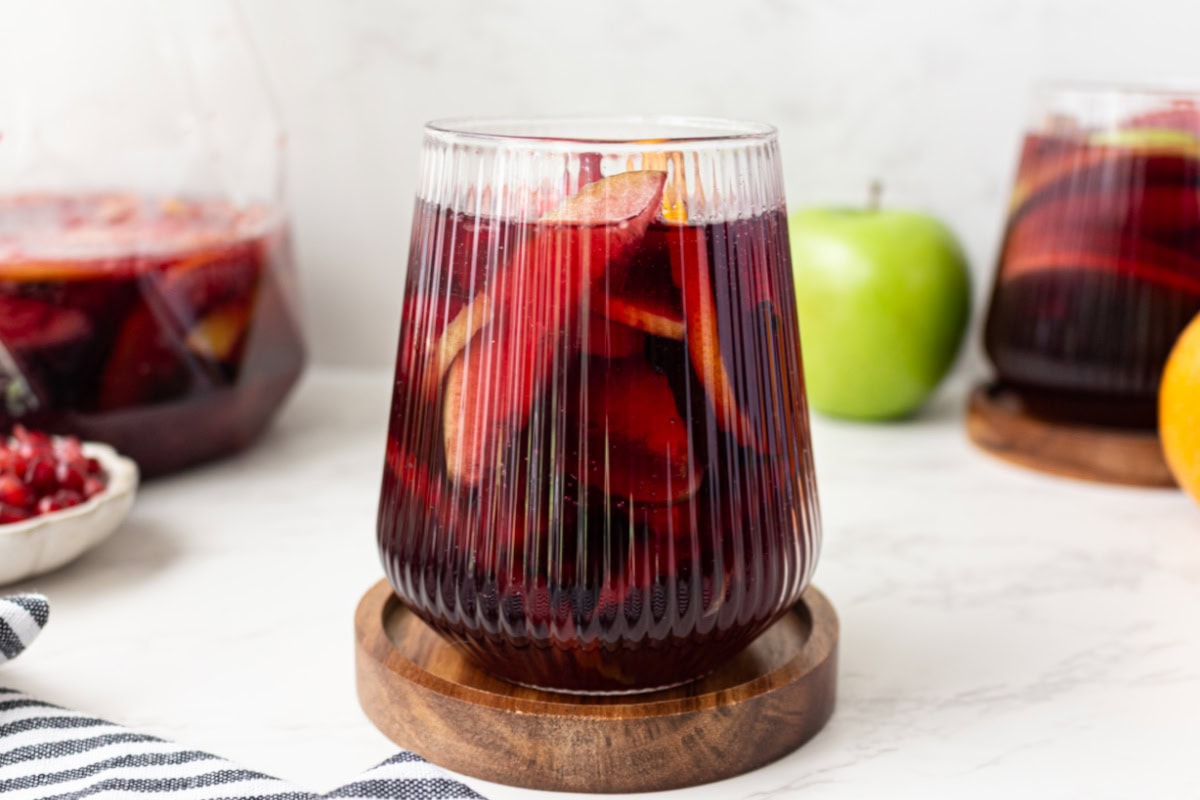 This sangria has all of the flavors of fall! Recipe from RecipeGirl.com. side shot of a glass of fall sangria