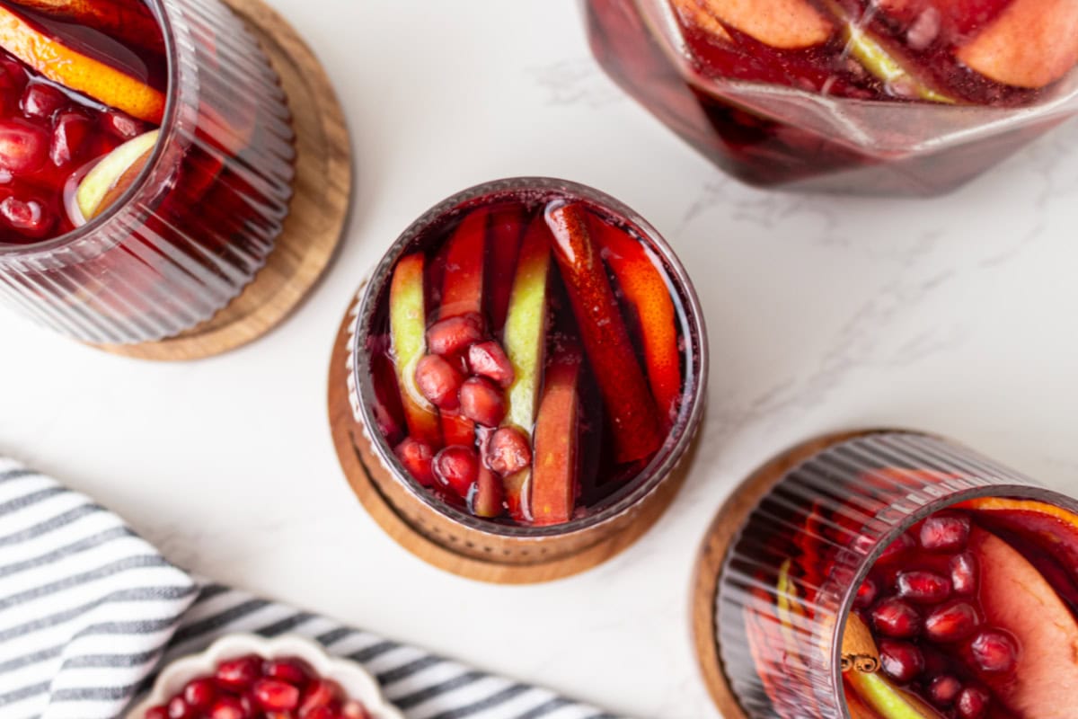 This sangria has all of the flavors of fall! Recipe from RecipeGirl.com. overhead shot of glasses of fall sangria
