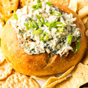 knorr spinach dip served in a bread bowl with crackers and bread slices surrounding