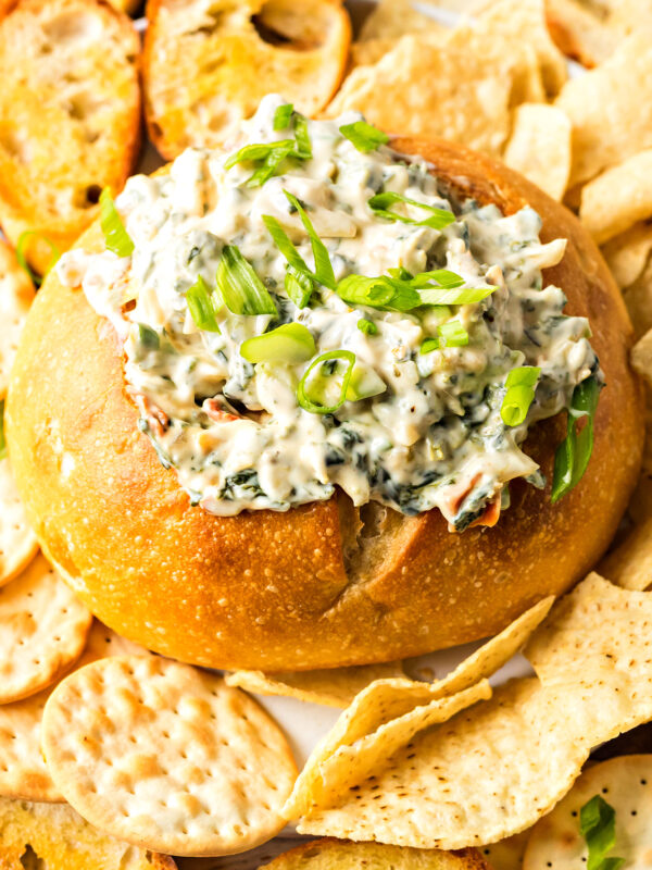 knorr spinach dip served in a bread bowl with crackers and bread slices surrounding