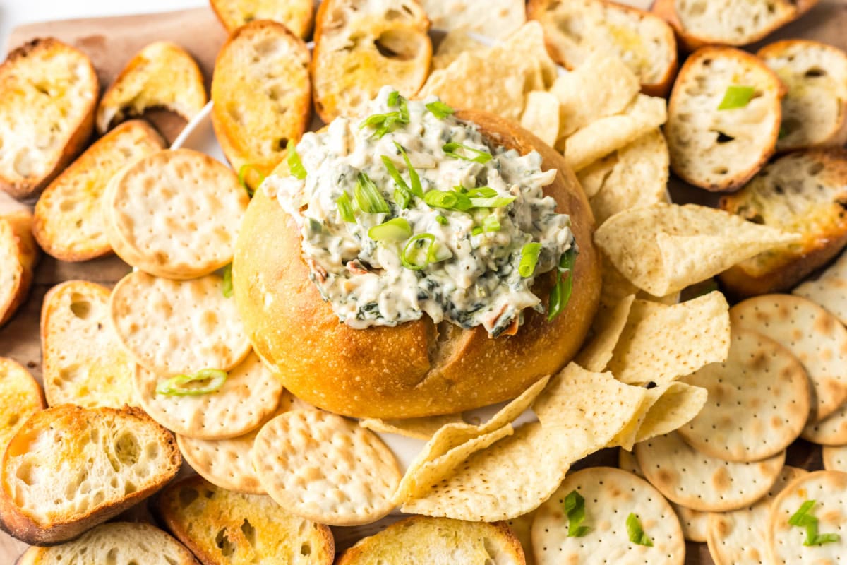This Knorr Spinach Dip in a bread bowl is creamy, classic, and easy! A timeless appetizer perfect for holidays, game day, or parties. Recipe on RecipeGirl.com. knorr spinach dip served in a bread bowl