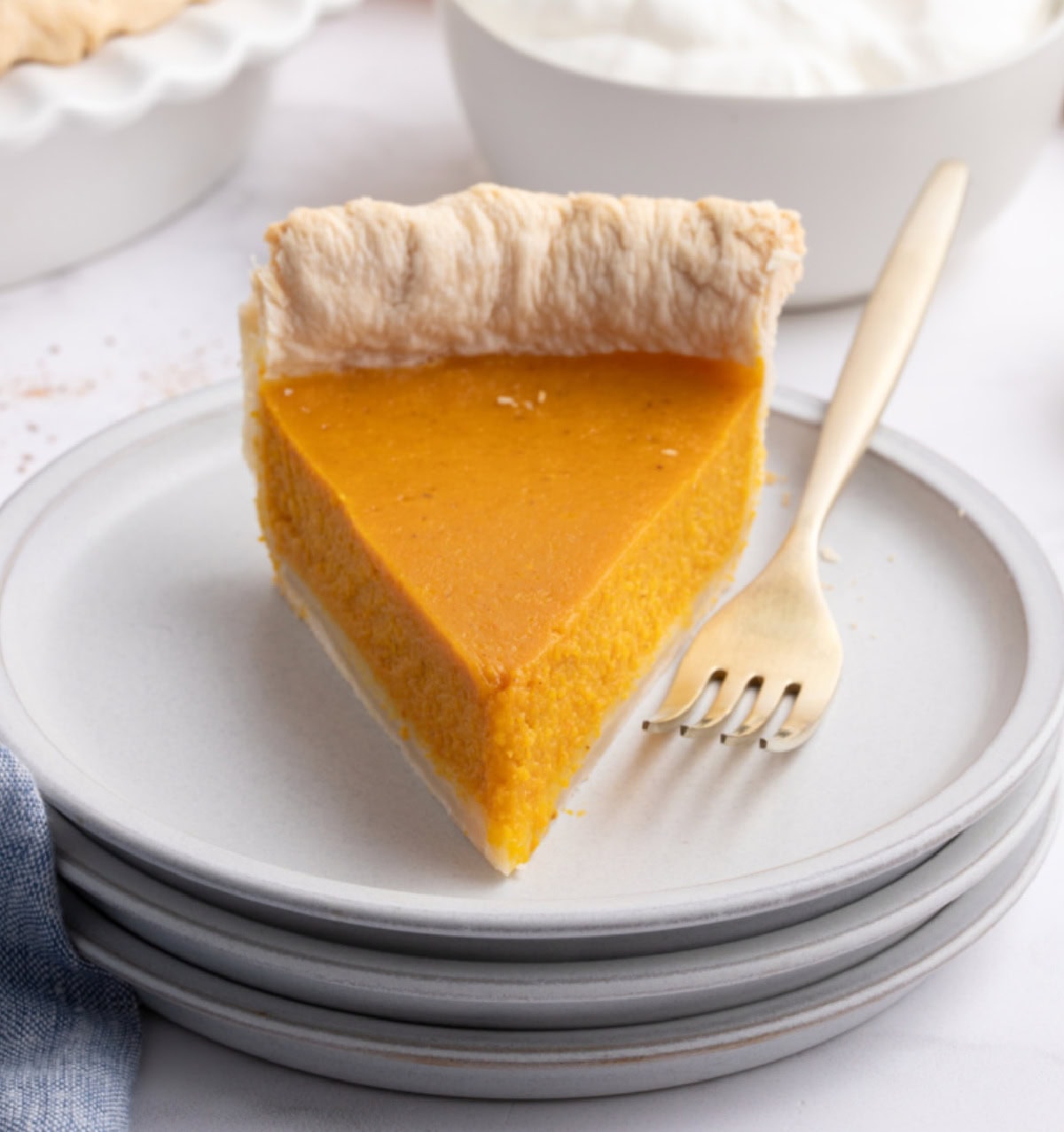 This is an easy and delicious family pumpkin pie recipe. slice of pumpkin pie on a plate
