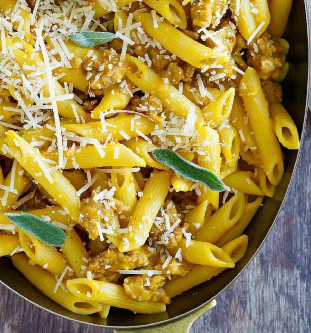 Pasta with Pumpkin and Sausage is freshly cooked penne pasta is tossed in a simply seasoned pumpkin sauce with crumbled Italian sausage added in too. serving of pasta with pumpkin and sausage in a bowl