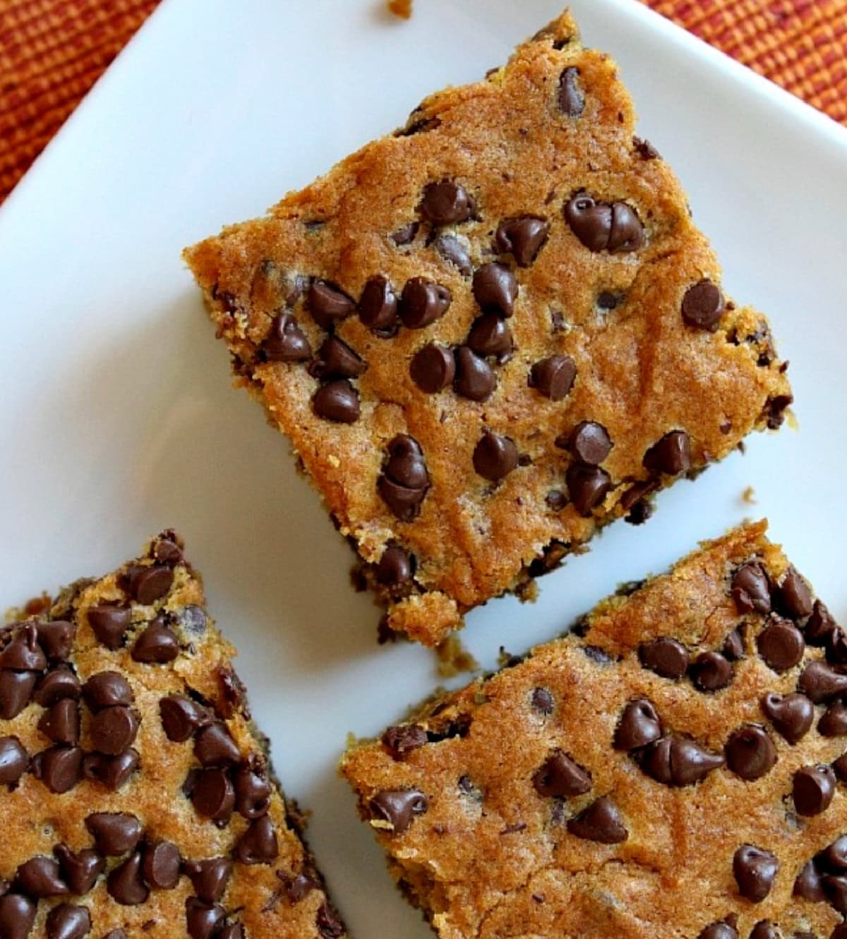 These Pumpkin Chocolate Chip Squares are an easy-to-make fall treat. Tender pumpkin cake with plenty of chocolate. Three pumpkin chocolate chip squares