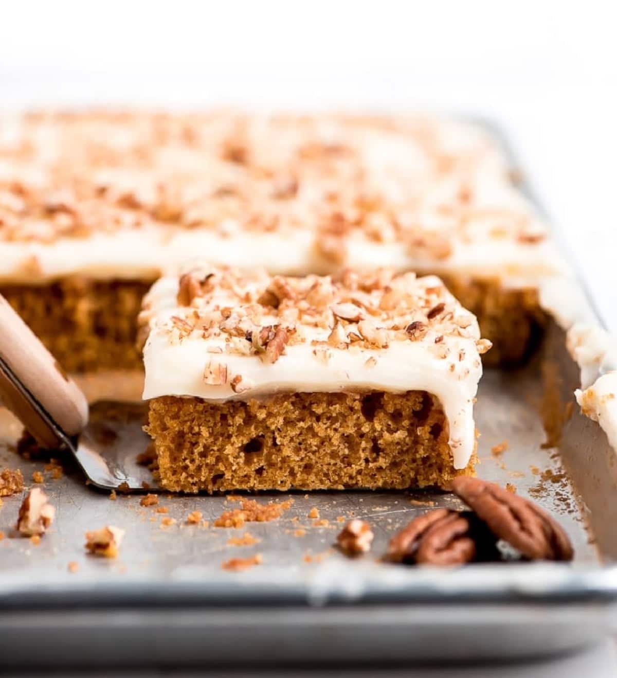 Pumpkin Sheet Cake has a tender moist crumb pumpkin cake and is topped with silky smooth cream cheese frosting. pumpkin sheet cake with one slice taken out and displayed