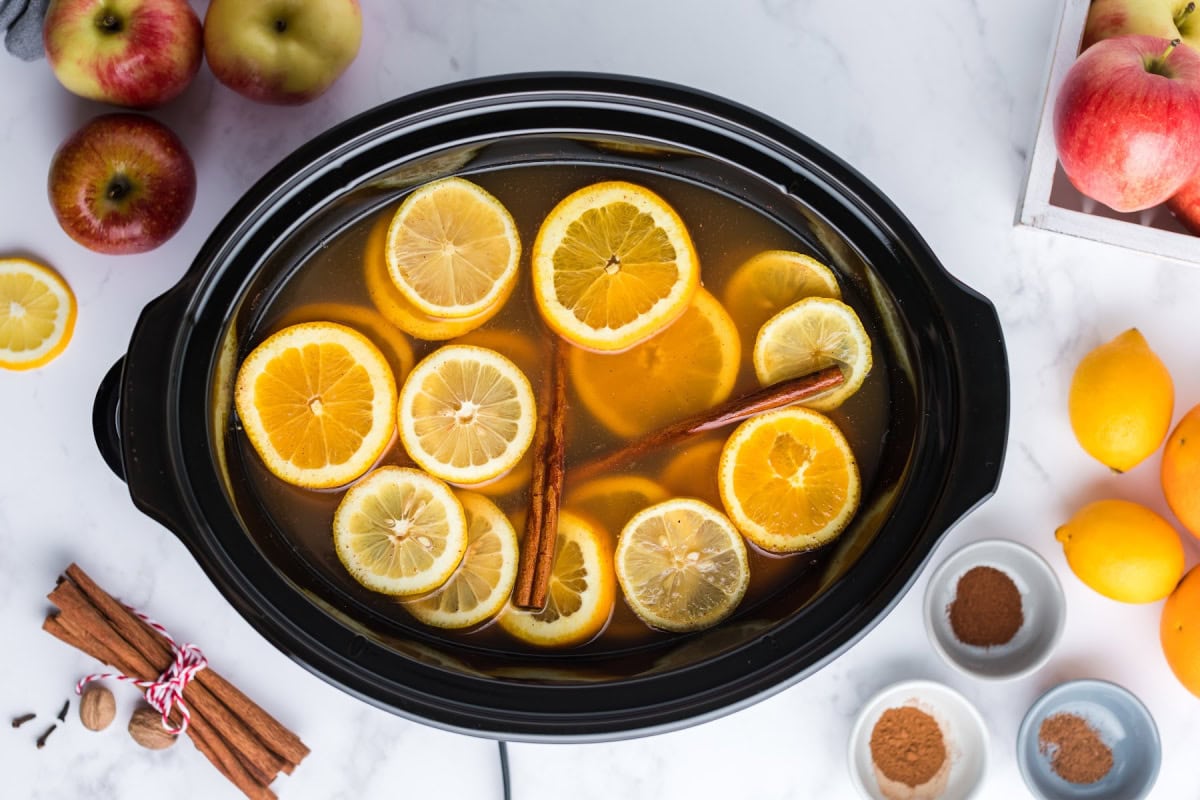Slow Cooker Mulled Cider is the ultimate perfect warm, non-alcoholic apple cider beverage to make and enjoy during the fall and winter months. Recipe from RecipeGirl.com. crockpot full of slow cooker mulled cider