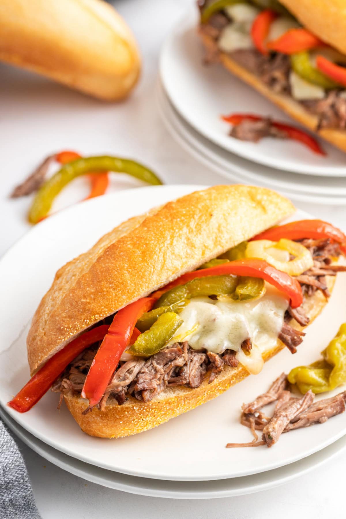 Slow Cooker Italian Beef Sandwiches are the best sandwiches ever. The beef is cooked with pepperoncini and Italian dressing, then shredded. Recipe from RecipeGirl.com. slow cooker italian beef sandwich on a plate