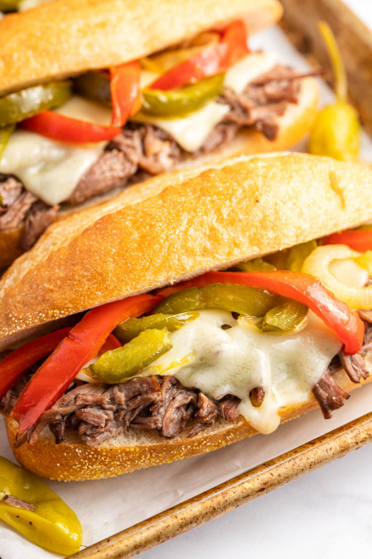 Slow Cooker Italian Beef Sandwiches are the best sandwiches ever. The beef is cooked with pepperoncini and Italian dressing, then shredded. Recipe from RecipeGirl.com. close up slow cooker italian beef sandwich