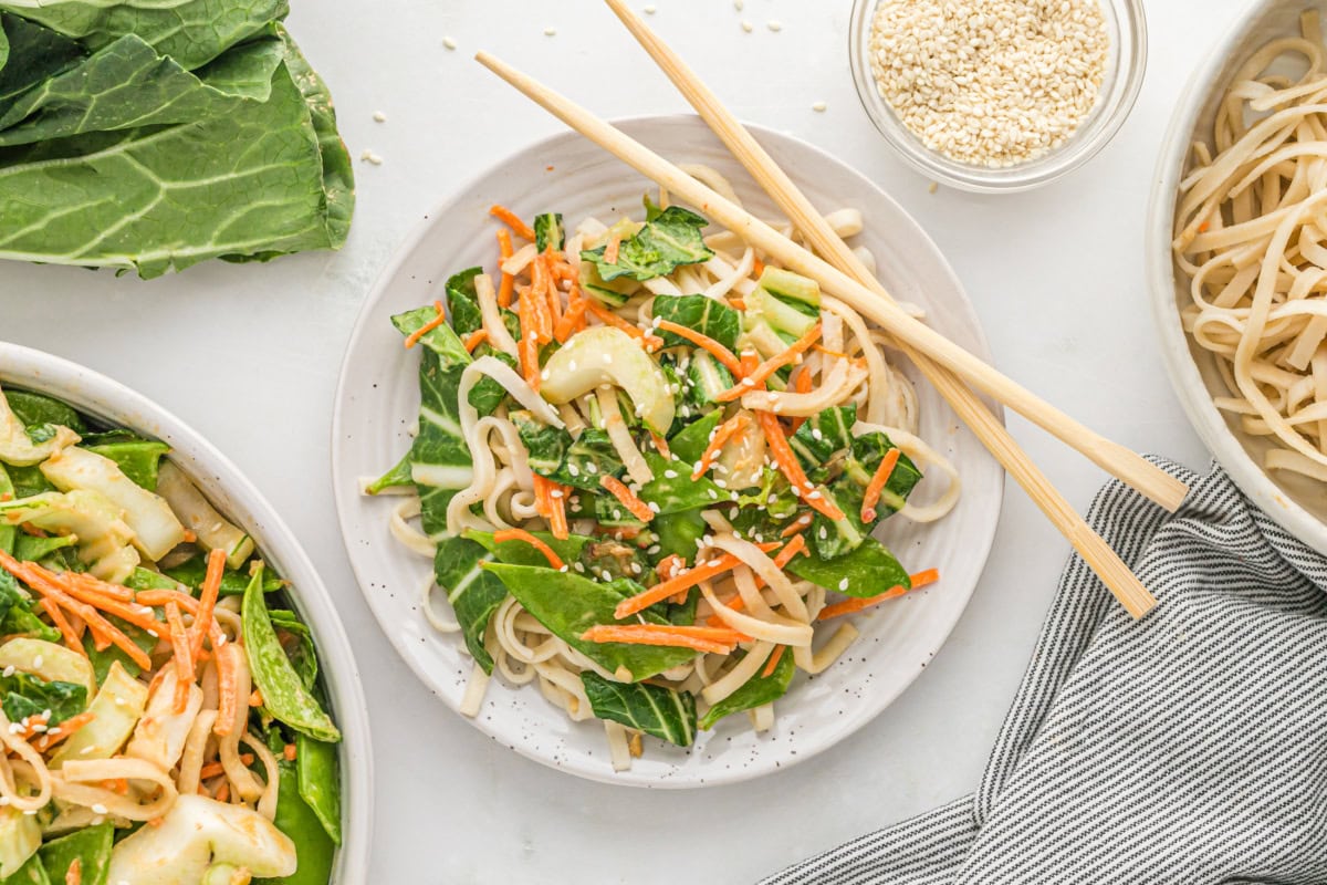 If you love a little heat, these Spicy Peanut Noodles will be your new obsession. A creamy, nutty sauce coats noodles and crunchy veggies — fast, flavorful, and perfect for busy weeknights! serving of spicy peanut noodles on plate with chopsticks